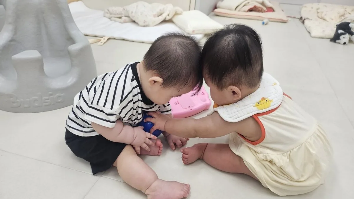 친구와 머리를 맞대고 장난감을 함께 만지는 로희