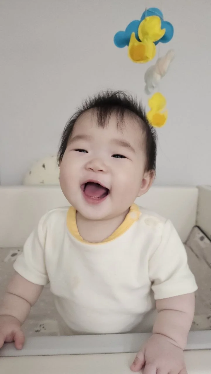 모빌 아래에서 환하게 웃는 로희